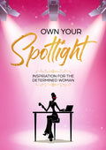 Journal cover features three Hollywood style lights beaming down on the title "Own Your Spotlight" and caption "Inspiration For The Determined Woman." A silhouette of a woman featured in the spotlight is sitting at a rectangular desk typing on her laptop while holding a cup of coffee.